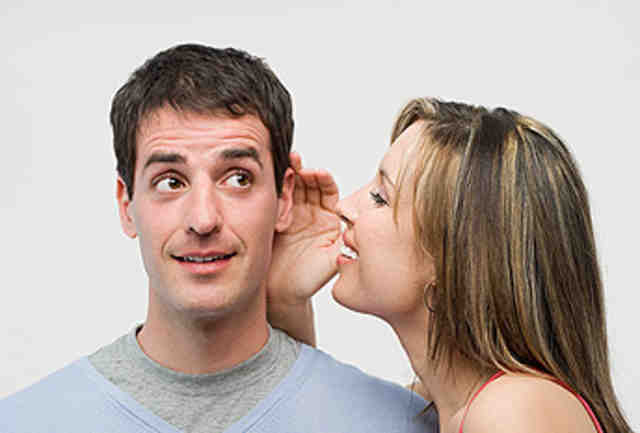 Woman whispering to man